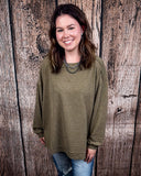 The Stillwater Tunic Top in Olive being styled and modeled on women in front of wooden backdrop.