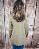 The Stillwater Tunic Top in Olive being styled and modeled on women in front of wooden backdrop.