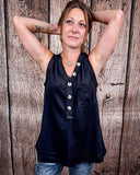 The Lanie Tank in black being styled and modeled by a women in front of wood background.