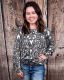 Tooled in Love Ribbed Sweater Top being modeled and styled on a women in front of wood backdrop.
