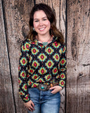 The Palmer Pullover being styled with jeans and worn by a women in front of wood background.