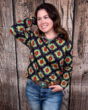 The Palmer Pullover being styled with jeans and worn by a women in front of wood background.