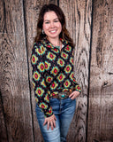 The Palmer Pullover being styled with jeans and worn by a women in front of wood background.