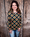The Palmer Pullover being styled with jeans and worn by a women in front of wood background.