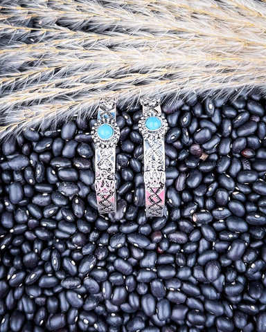 Thunderbird Hoop Fashion Earrings displayed on black pebbles and wheat background.