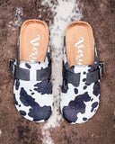 Andi Slip on Mule in Black Cow Print by Very G displayed on cowhide.