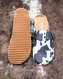 Andi Slip on Mule in Black Cow Print by Very G displayed on cowhide.
