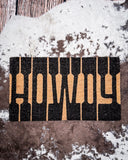 Howdy Coir Doormat displayed on cowhide.