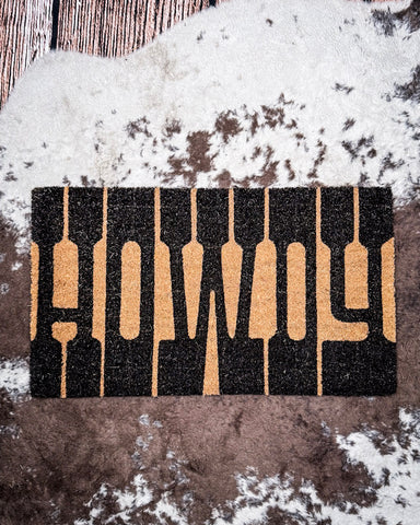Howdy Coir Doormat displayed on cowhide.