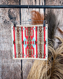Ojo Caliente Towels displayed on a rod in front of wood background.