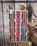 Ojo Caliente Towels displayed on a rod in front of wood background.