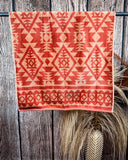 Navajo Adobe Towels displayed on rod in front of wood background.