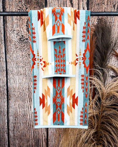 Pecos Towels displayed on rode in front of wood and wheat backdrop.