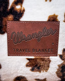 Close up of Wrangler Tri-Color Cowhide Travel Blanket logo.