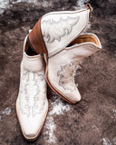 Side and front view of the Western Ember Booties in White displayed on cowhide.