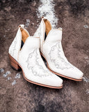 Side view of the Western Ember Booties in White displayed on cowhide.