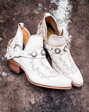 Side view of the Western Ember Booties in White displayed on cowhide.