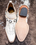 Front and bottom of the Western Ember Booties in White displayed on cowhide.
