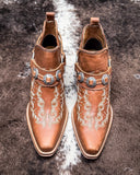 Front view of the Western Ember Booties in Canyon Brown displayed on cowhide.