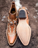 Front and bottom of the Western Ember Booties in Canyon Brown displayed on cowhide.