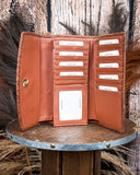 Inside of the Angelstone Wallet in Brown and White on a wooden table with wheat in the back.