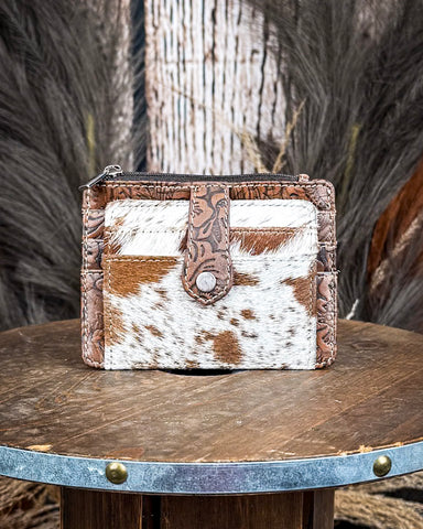 The Wonder Trail Card Holder in Caramel on a wooden table with wheat in the back, wood backdrop.