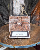 Inside of the Wonder Trail Card Holder in Caramel on a wooden table with wheat in the back.