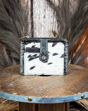 The Wonder Trail Card Holder in Black on a wooden table with wheat in the back,  wood backdrop.