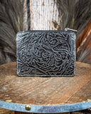 Back view of the Wonder Trail Card Holder in Black on a wooden table with wheat in the back.