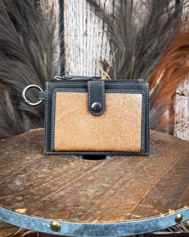 The Wind Rider Card Holder in Chocolate Brown on a wooden table with wheat in the back. 