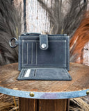 Inside of the Wind Rider Card Holder in Chocolate Brown on a wooden table with wheat in the back.