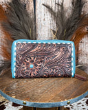 Leather wallet with intricate designs on a wooden surface