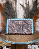 Handcrafted leather wallet with floral patterns on a wooden surface