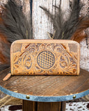 Handcrafted leather wallet with intricate patterns on a wooden surface