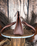 Brown leather bag on a wooden stand with a rustic background