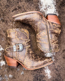 Pair of brown leather boots with decorative elements on a textured surface