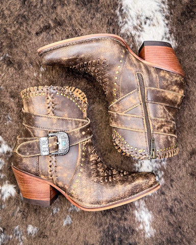 Pair of brown leather boots with decorative elements on a textured surface