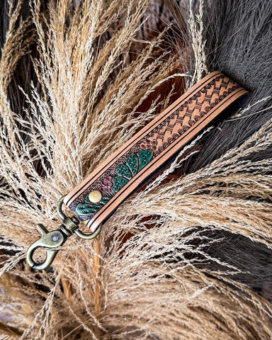 Decorative leather keychain with intricate patterns on a natural background