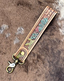 Decorative leather strap with floral patterns on a textured brown background