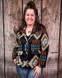 Woman wearing a patterned jacket standing against a wooden background