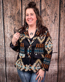 Woman wearing a patterned jacket against a wooden background