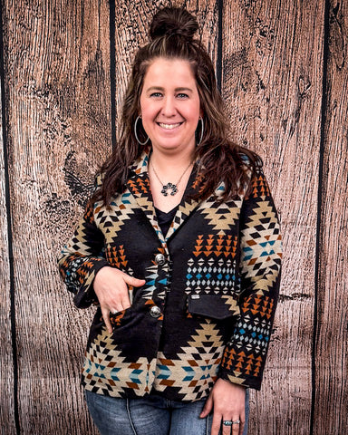Woman wearing a patterned jacket against a wooden background