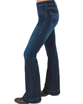 A side profile view of a person wearing dark blue flare jeans with purple contrast stitching and brown boots, shown against a plain white background.