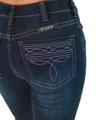 Close-up of the back of dark blue denim jeans worn by a model, showing a purple embroidered floral pattern on the back pocket and a black brand label reading TUFF.