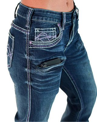Close-up of a person wearing dark blue denim jeans with purple contrast stitching and a black smartphone tucked into the back pocket.