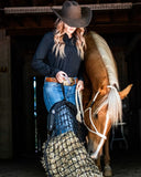 Woman in a cowboy hat with a horse in a barn setting