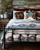 Bedroom with a bed featuring a patterned comforter, pillows, and a brick wall with a painting.
