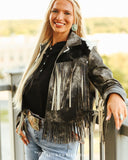 Woman wearing a fringed leather jacket with a blurred outdoor background