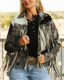 Person wearing a fringed jacket with a blurred outdoor background