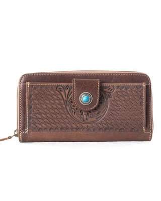 A brown leather zip-around wallet with embossed floral and basketweave patterns, featuring a snap-button closure with a turquoise stone accent.
